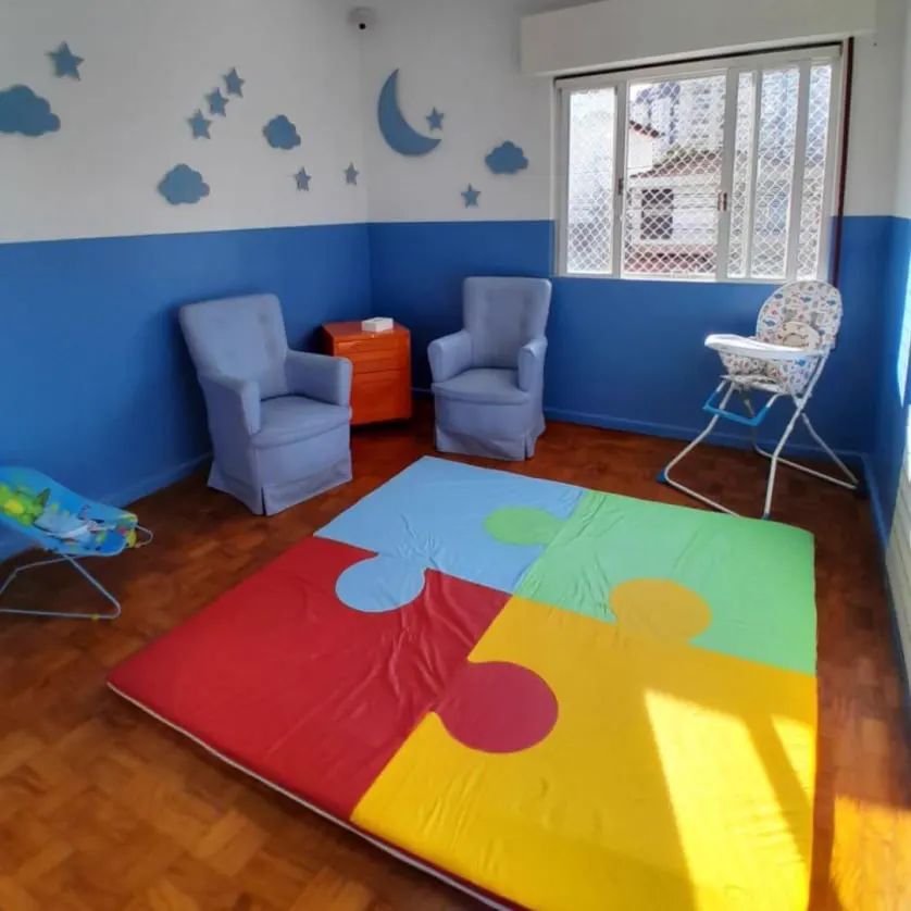 Sala aconchegante com tapete de quebra-cabeça colorido e poltronas