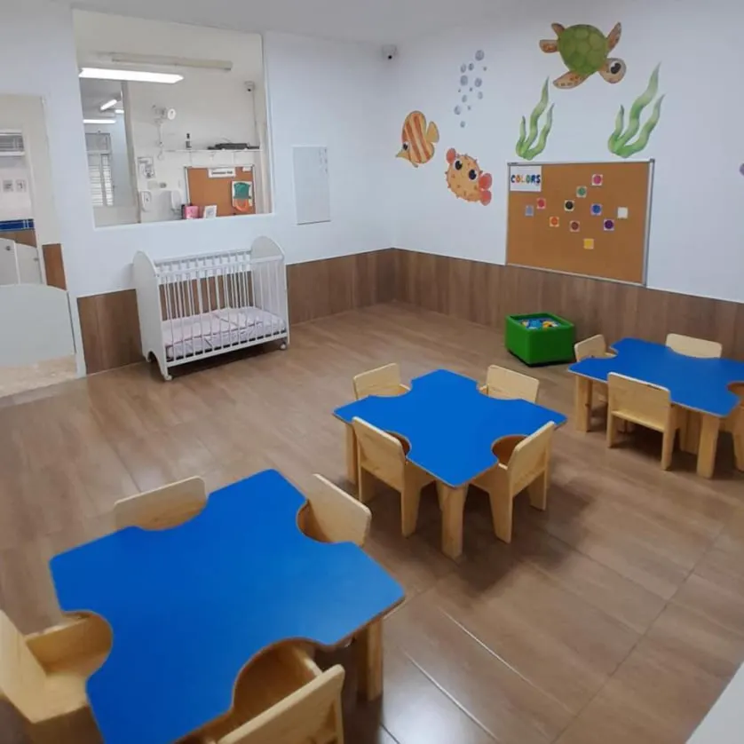 Sala do berçário com berço e mesinhas azuis