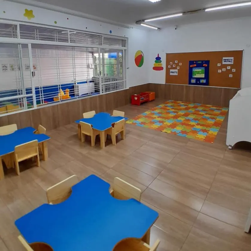 Sala do berçário com mesinhas e tapete colorido