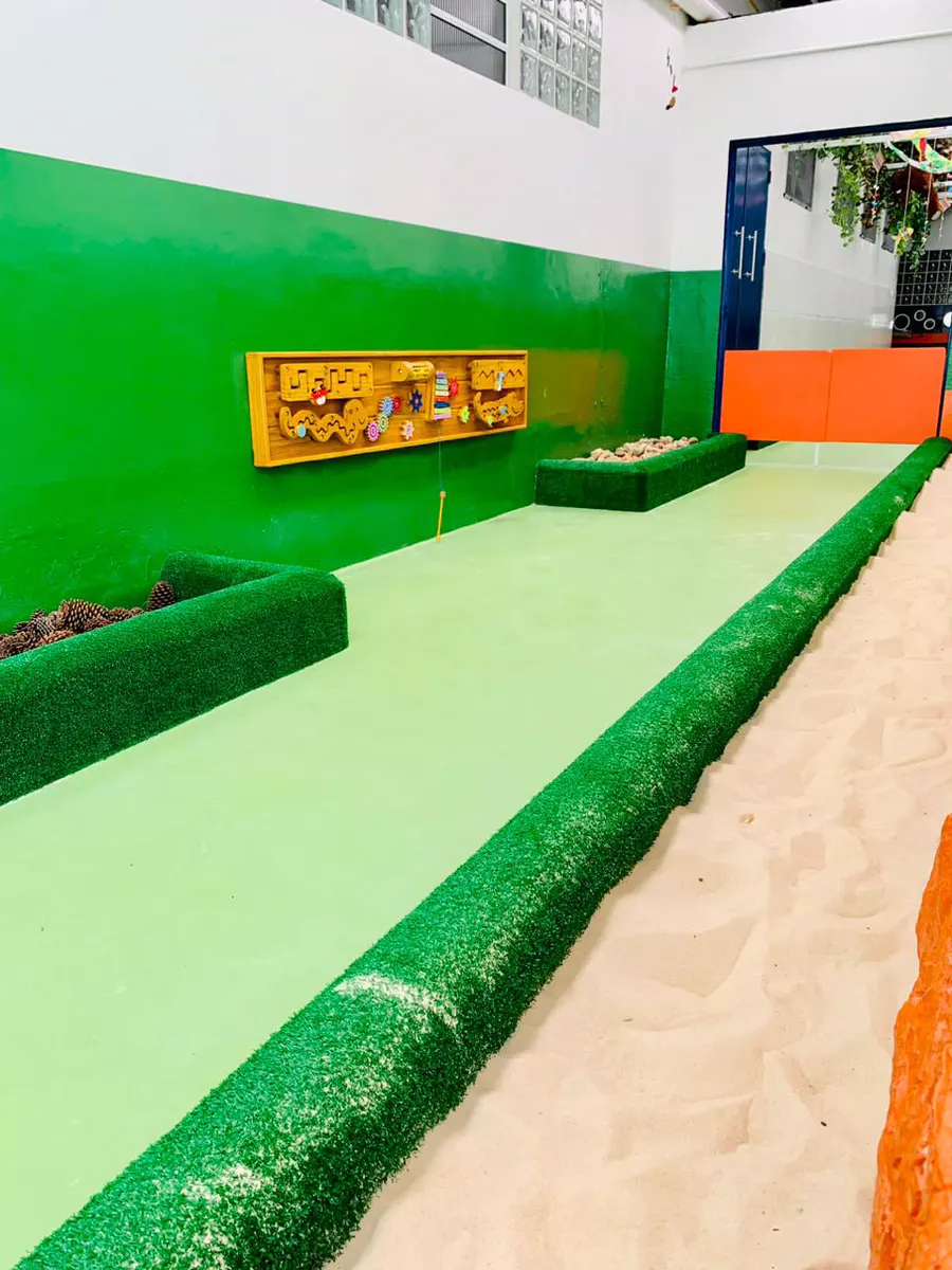 Tanque de areia com bordas de grama sintética