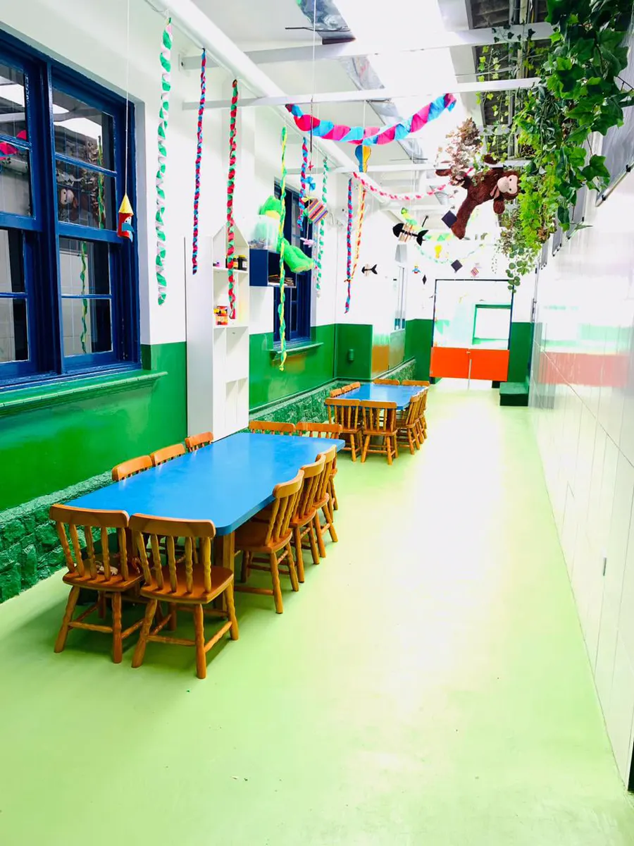 Área coberta com mesas e decoração colorida