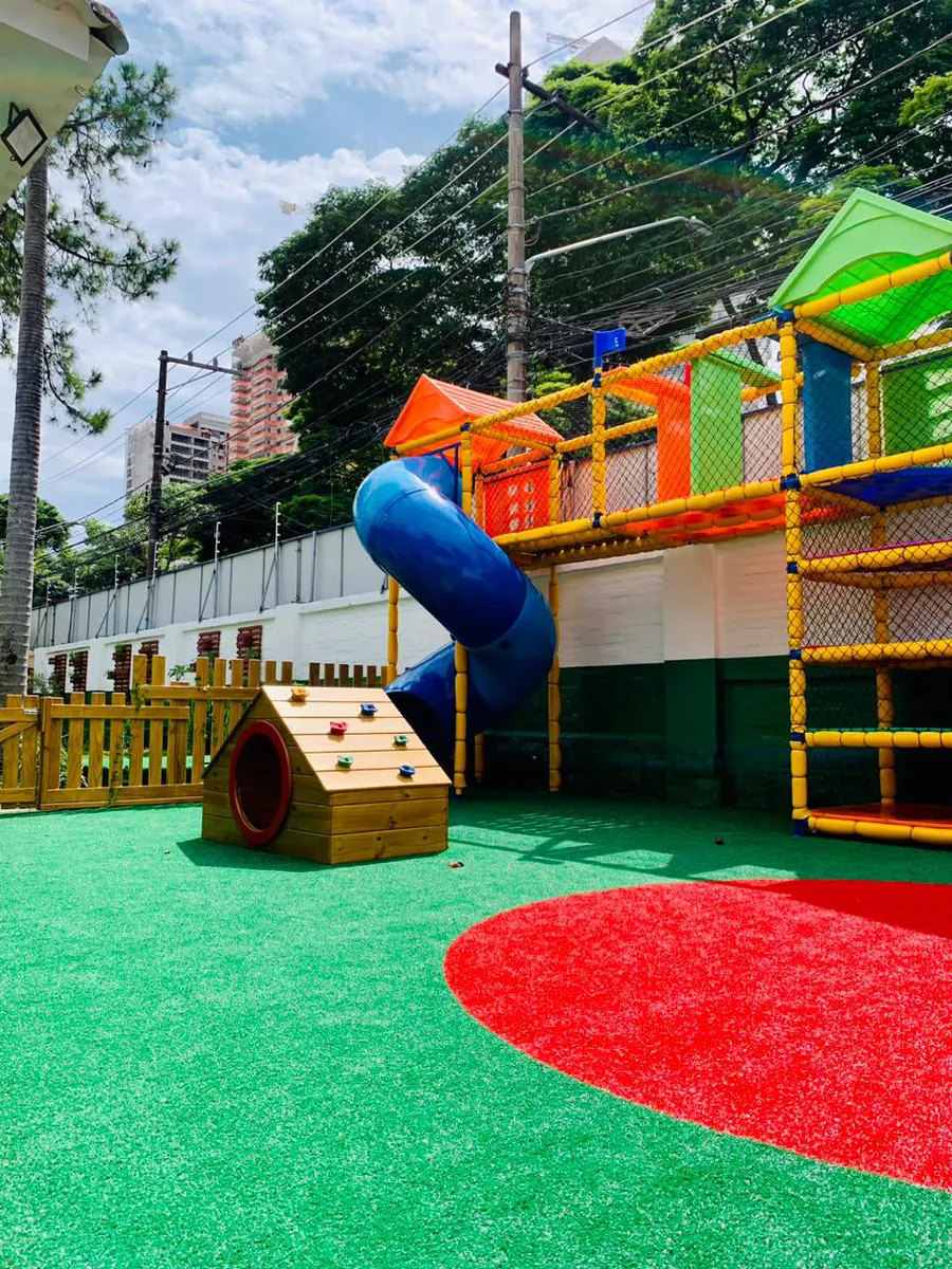 Playground externo com escorregador tubo e gramado